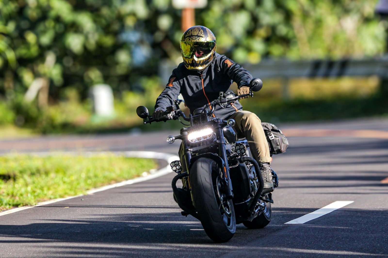 person with helmet riding down a street on a motorcycle that has been covered by Vireya motorcycle insurance
