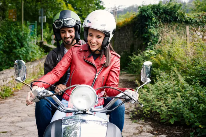 woman and man riding a moped covered with insurance from Vireya