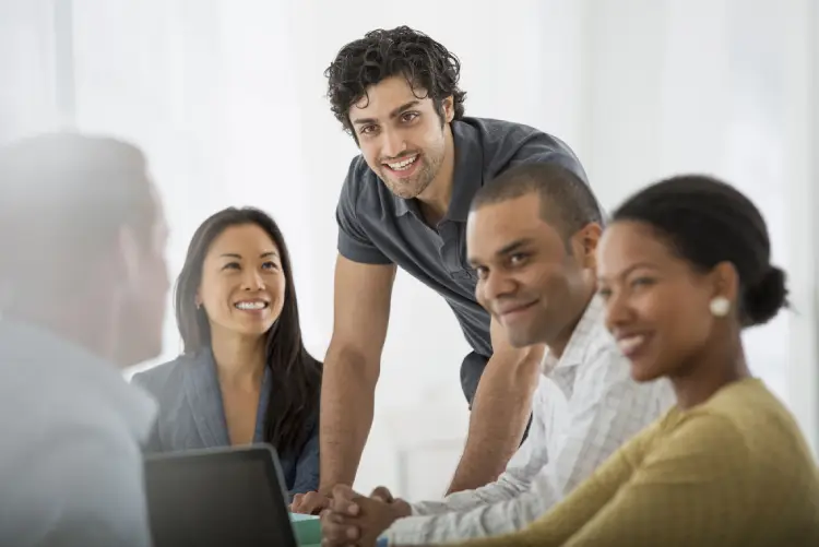 Diverse team of professionals smiling and collaborating in a bright meeting room