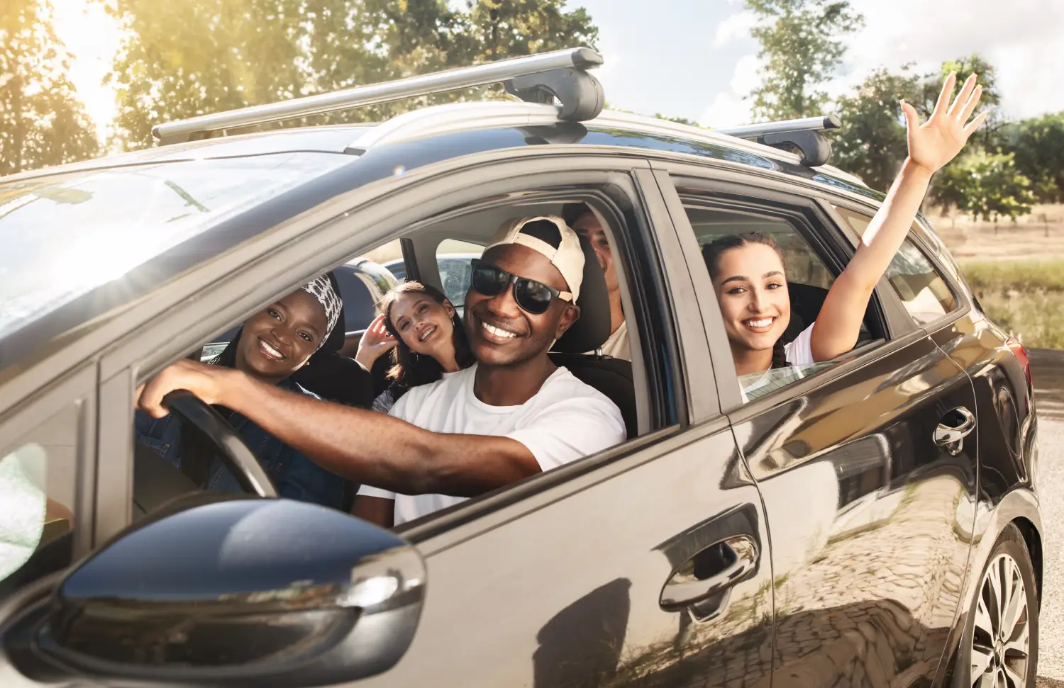 man driving a car covered with Vireya auto insurance with his friends in the passenger and back seats. all are smiling